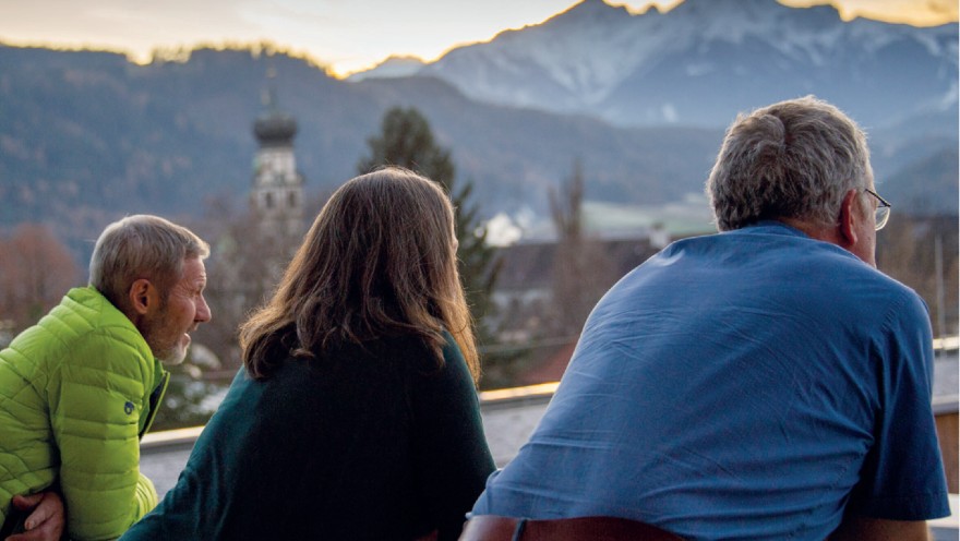 Zwei Hospizmitarbeitende sehen auf das abendliche Bergpanorama
