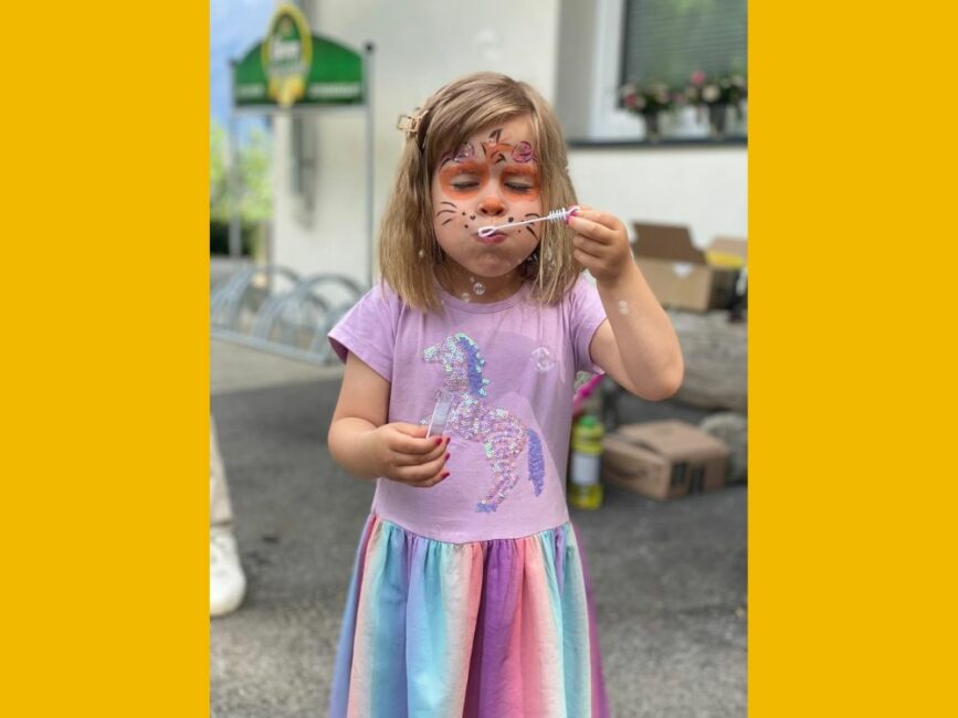 Geschminktes Mädchen macht Seifenblasen