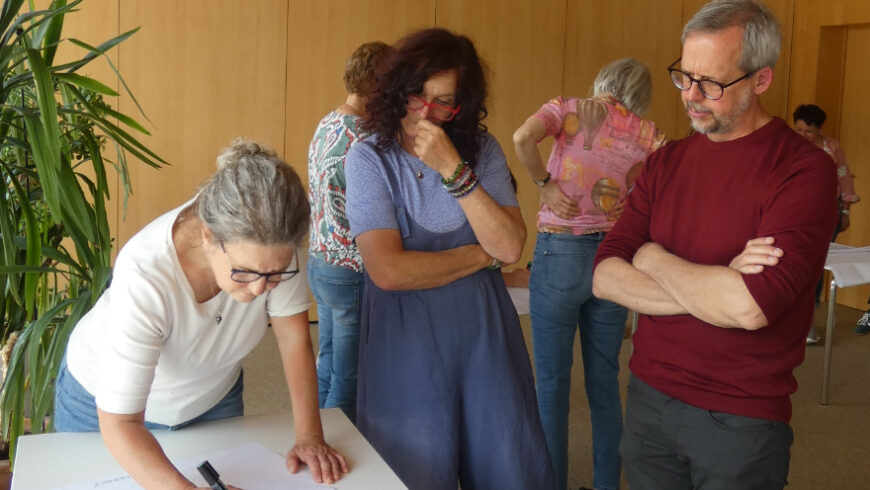 Die Seminarteilnehmer*innen beim beschriften ihres Flipcharts