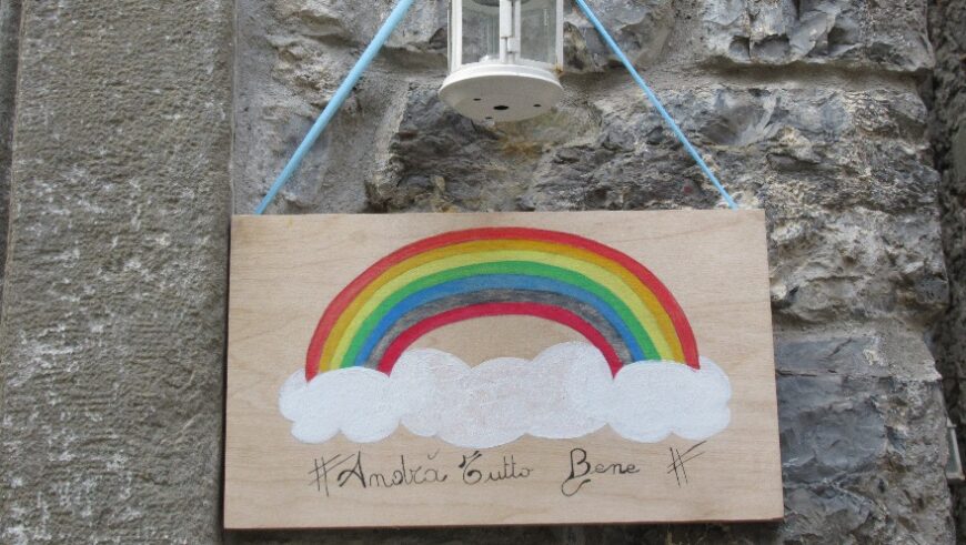 Ein Schild mit einem Regenbogen und darunter weißen Wolken