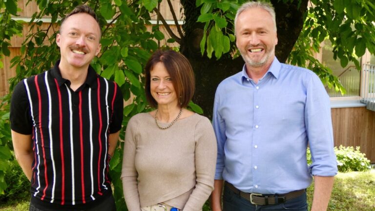 Robert Profunser, Andrea Knoflach-Gabis und Werner Mühlböck vor einem Baum im Garten des Hospizhauses