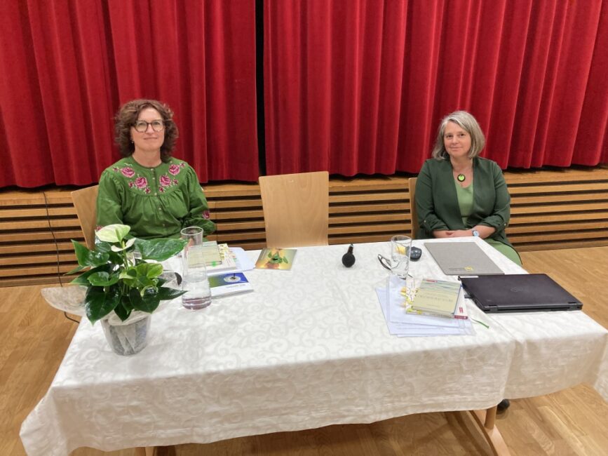 Monika Osl und Petra HIllebrand sitzen hinter einem Tisch bei der Lesung